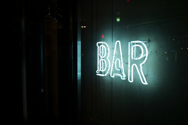 How can a bar reduce its environmental impact while maintaining a vibrant nightlife atmosphere?